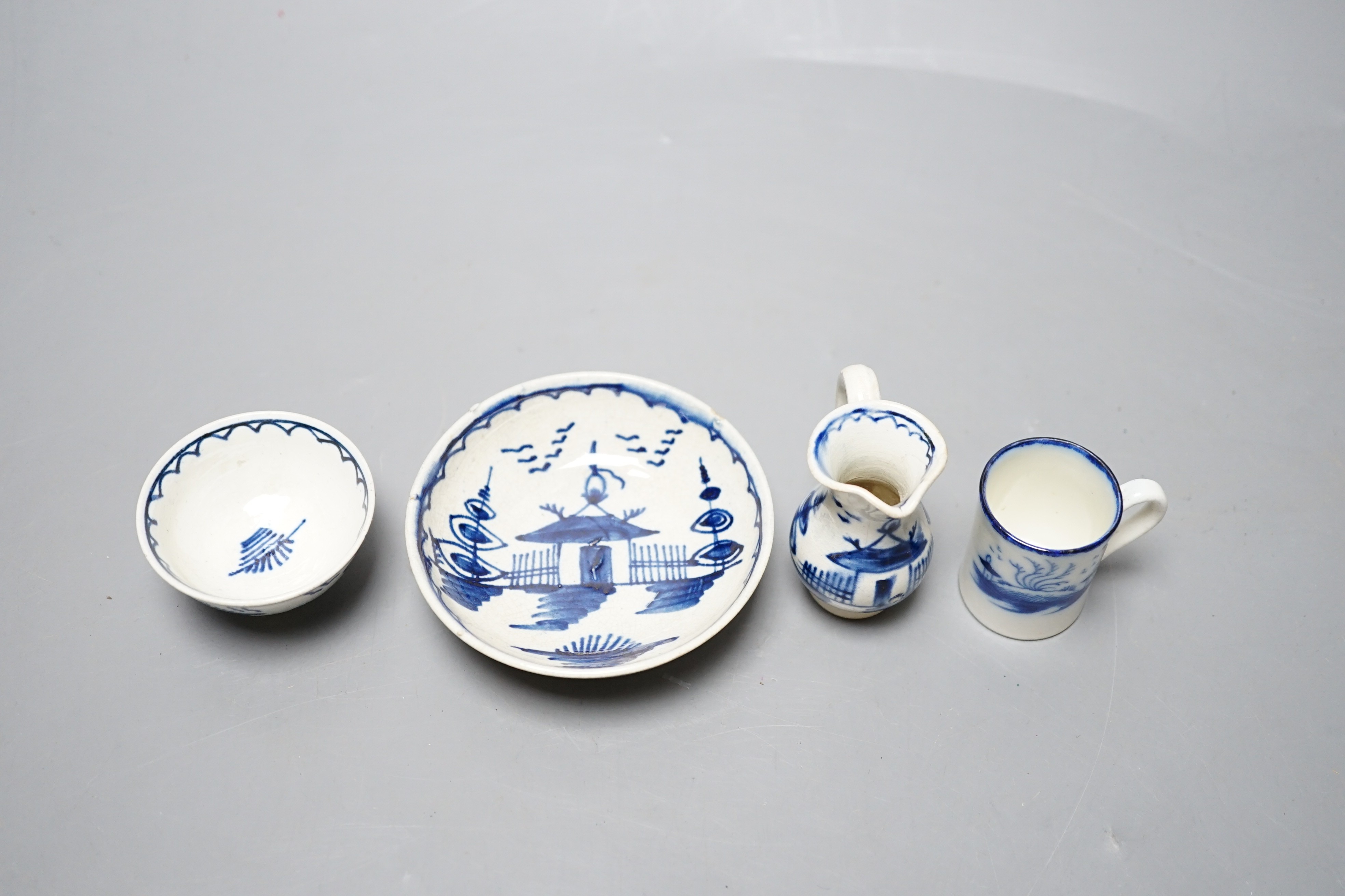 A late 18th century pearlware blue and white miniature jug, 5cm, and tea bowl and an English porcelain miniature mug, late 18th century